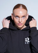 Person wearing a black hoodie with 'B27' branding against a light gray background